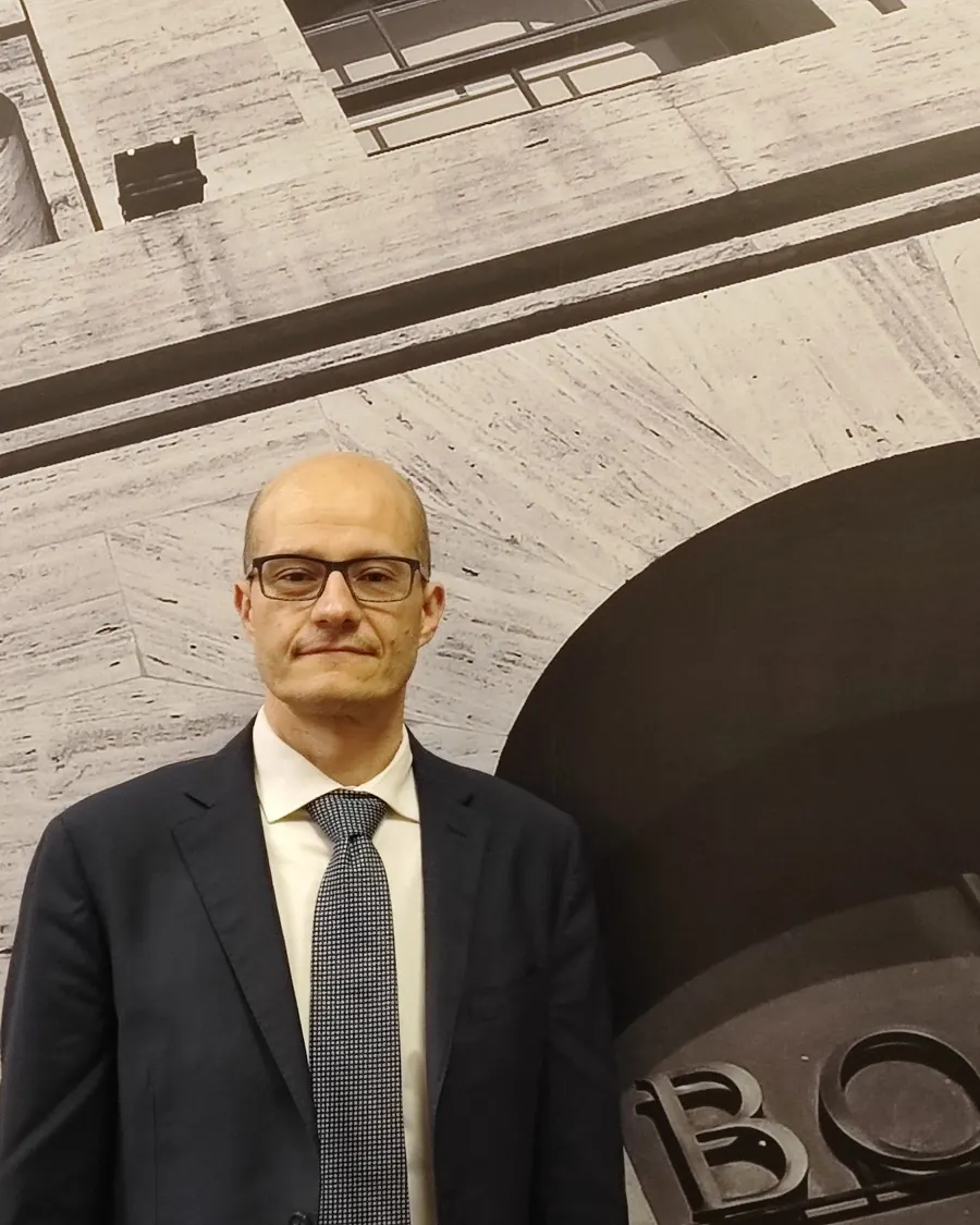 Simoneluca Mazzolini davanti a una grande immagine in bianco e nero con la scritta Borsa