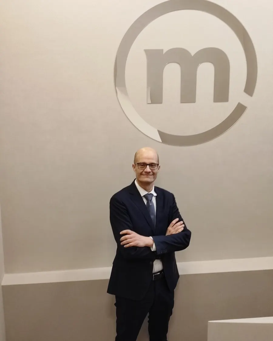 Simoneluca Mazzolini, a braccia conserte, davanti al logo Banca Mediolanum